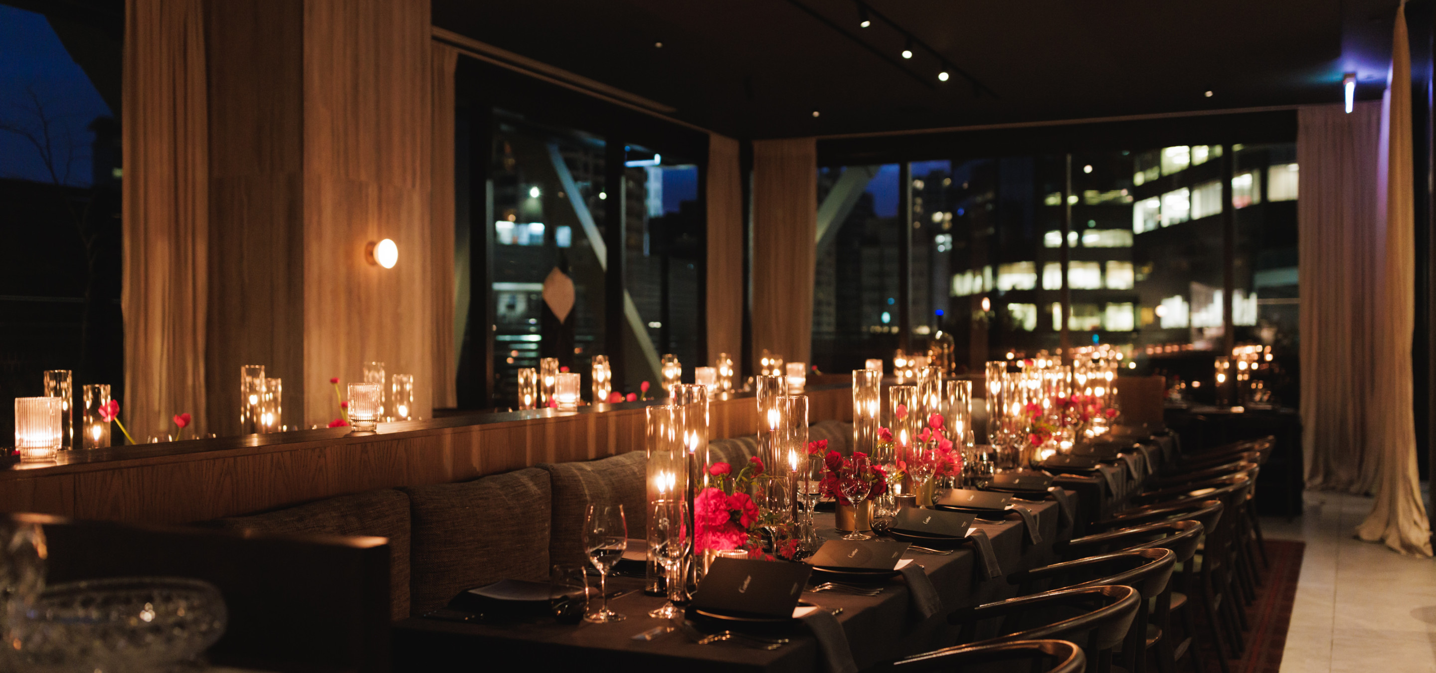 An intimate, candlelit private dining room at Onslow, Auckland's sophisticated modern restaurant, features a dark oak interior.