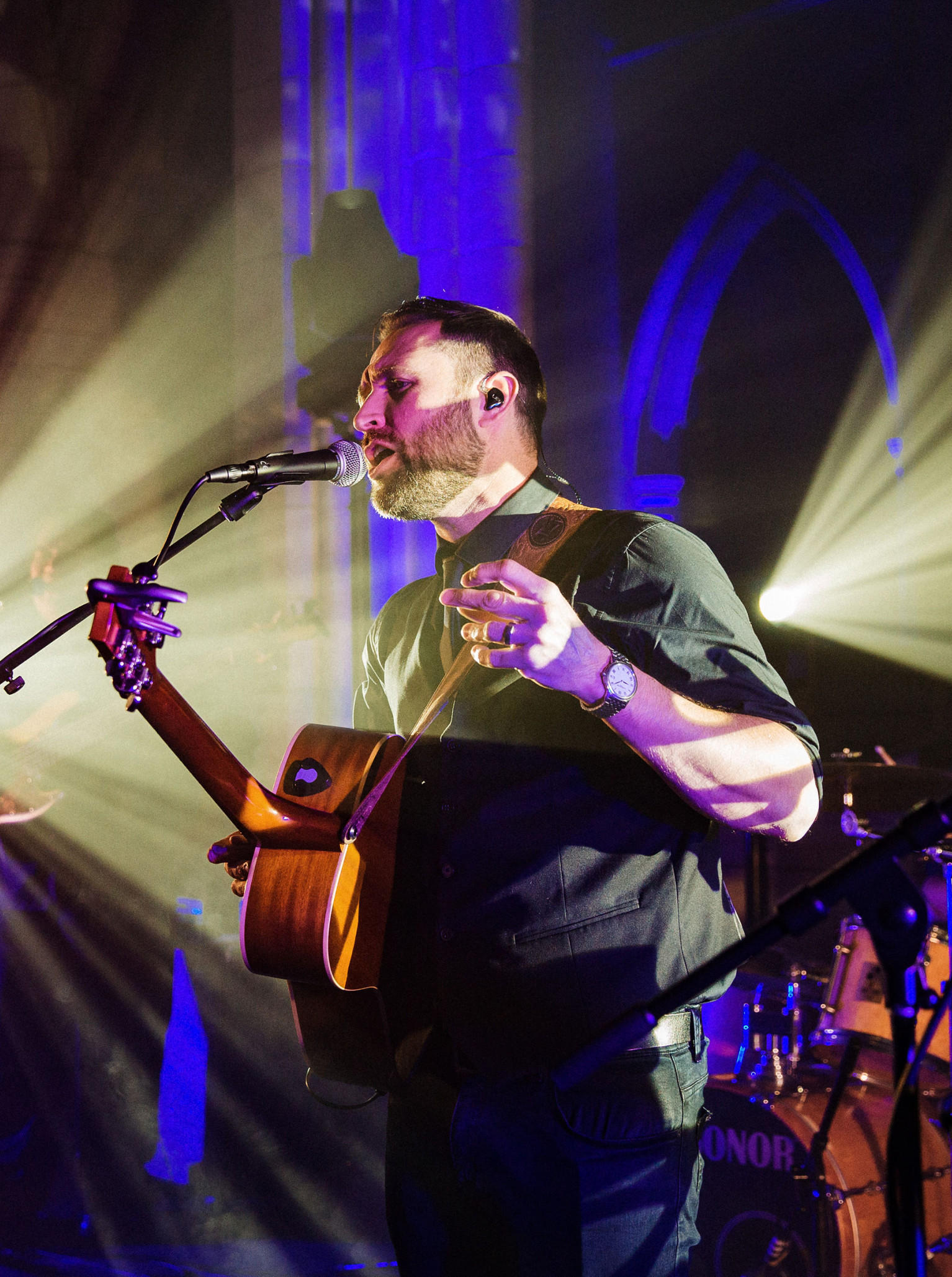 Lee Gray Music performs live in an Auckland venue, highlighted by dramatic lighting and historic gothic arches.