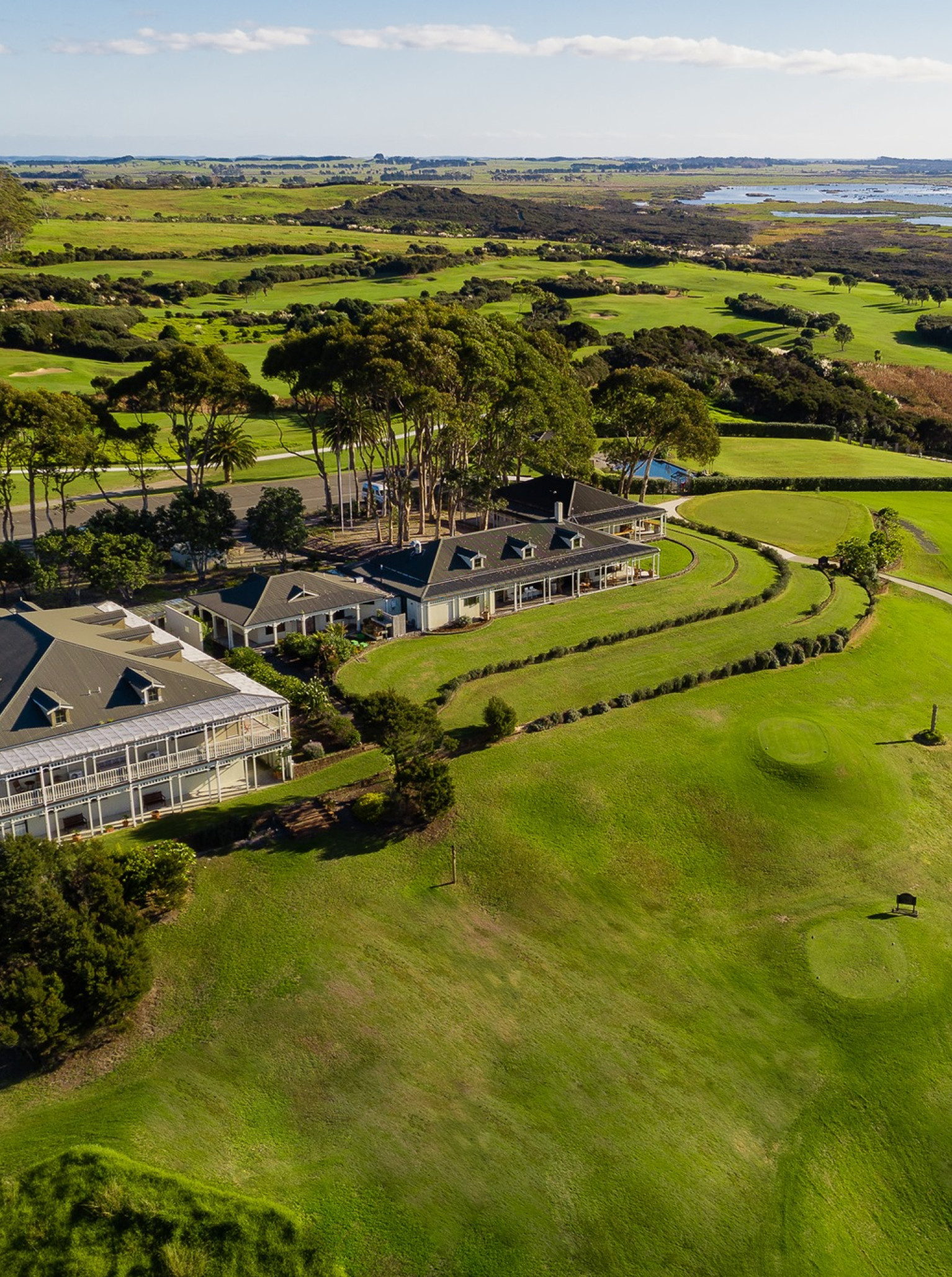 Aerial view of Carrington Estate in Northland, showcasing its elegant lodge-style buildings amidst an expansive golf course.