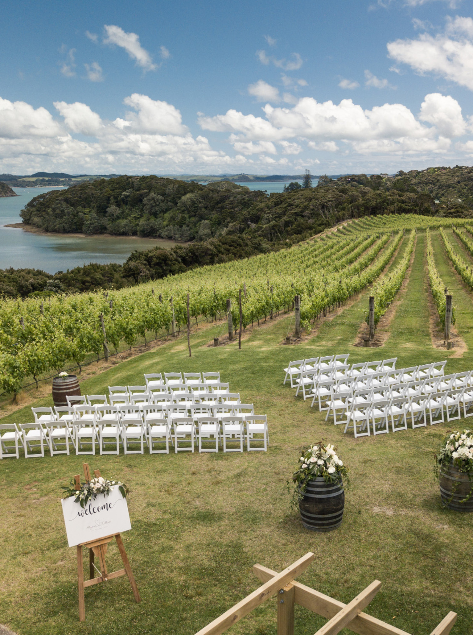 An outdoor ceremony set in the picturesque boutique vineyard of Omata Estate, Bay of Islands, overlooking the ocean.