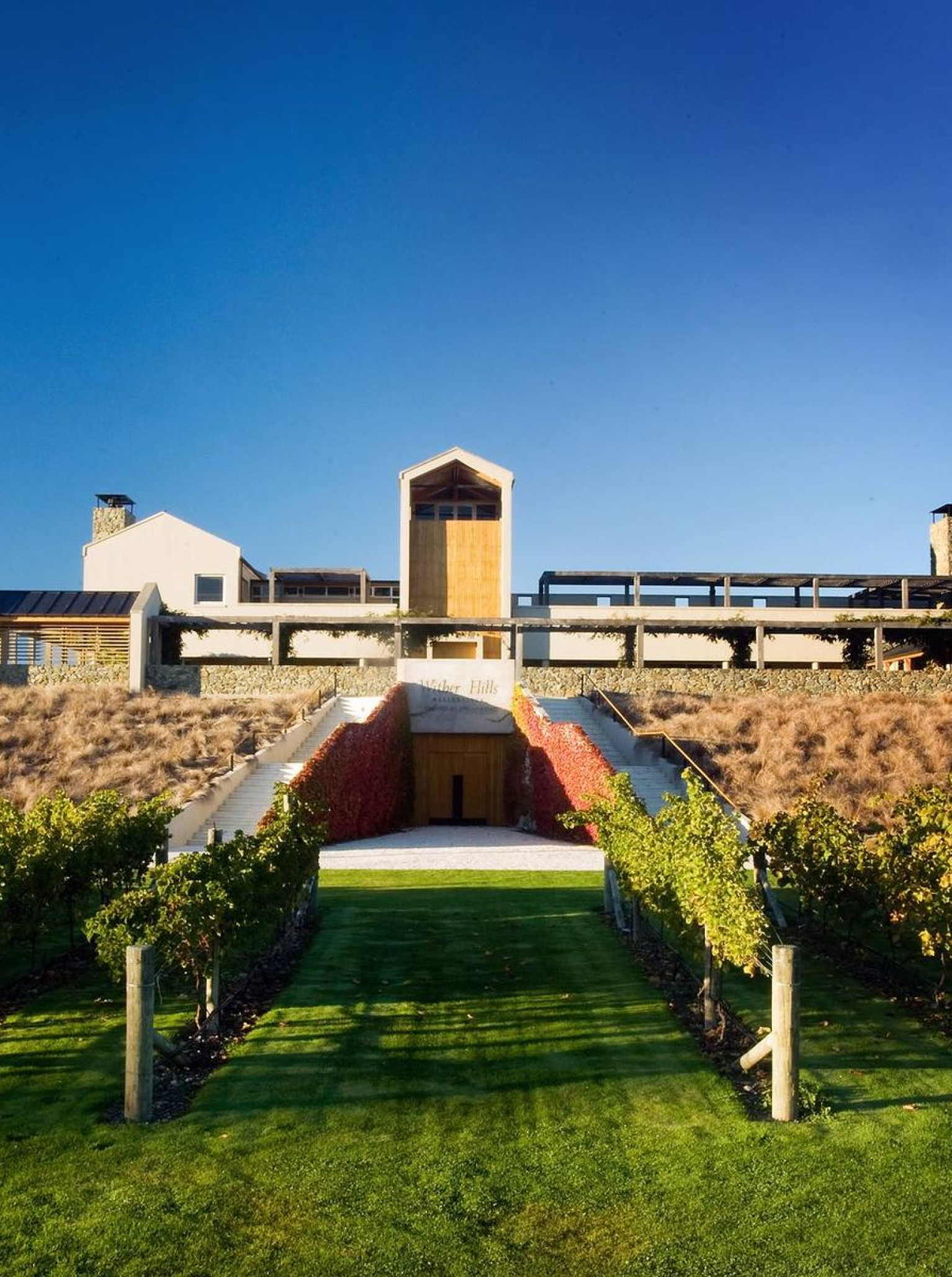 The contemporary cellar door of Wither Hills in Marlborough, with its striking stone and steepled tower, is nestled amongst lush vineyards.