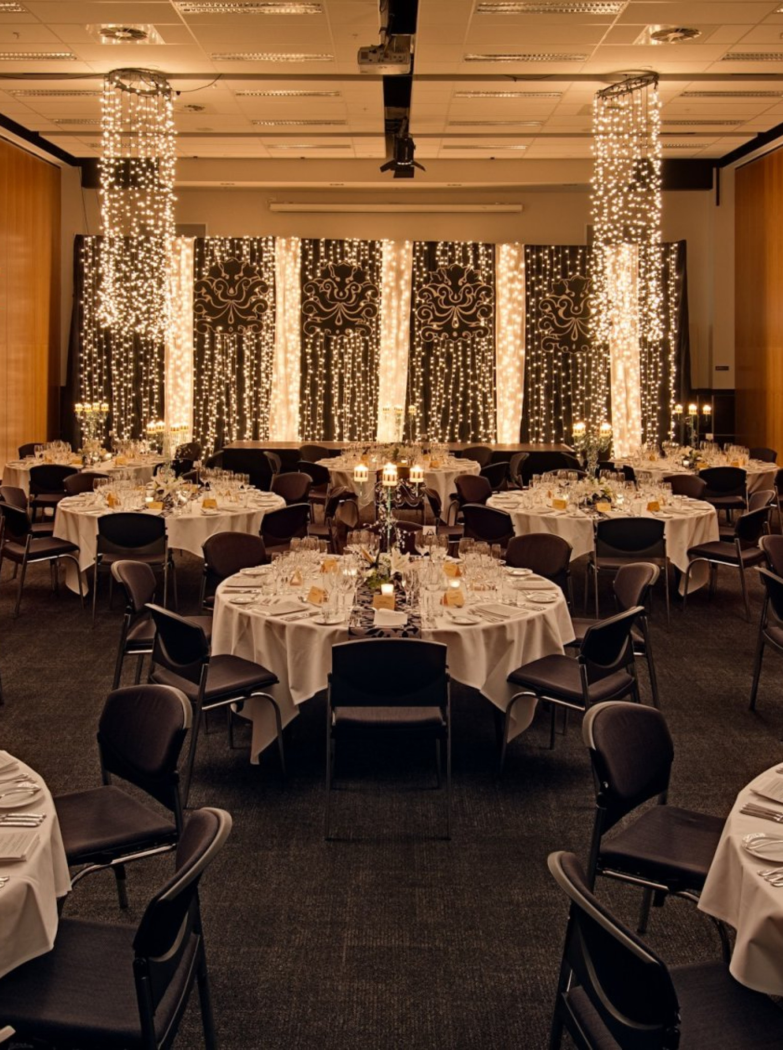Marlborough Events Centre's contemporary banquet setup features elegant dining tables and sparkling string lights.
