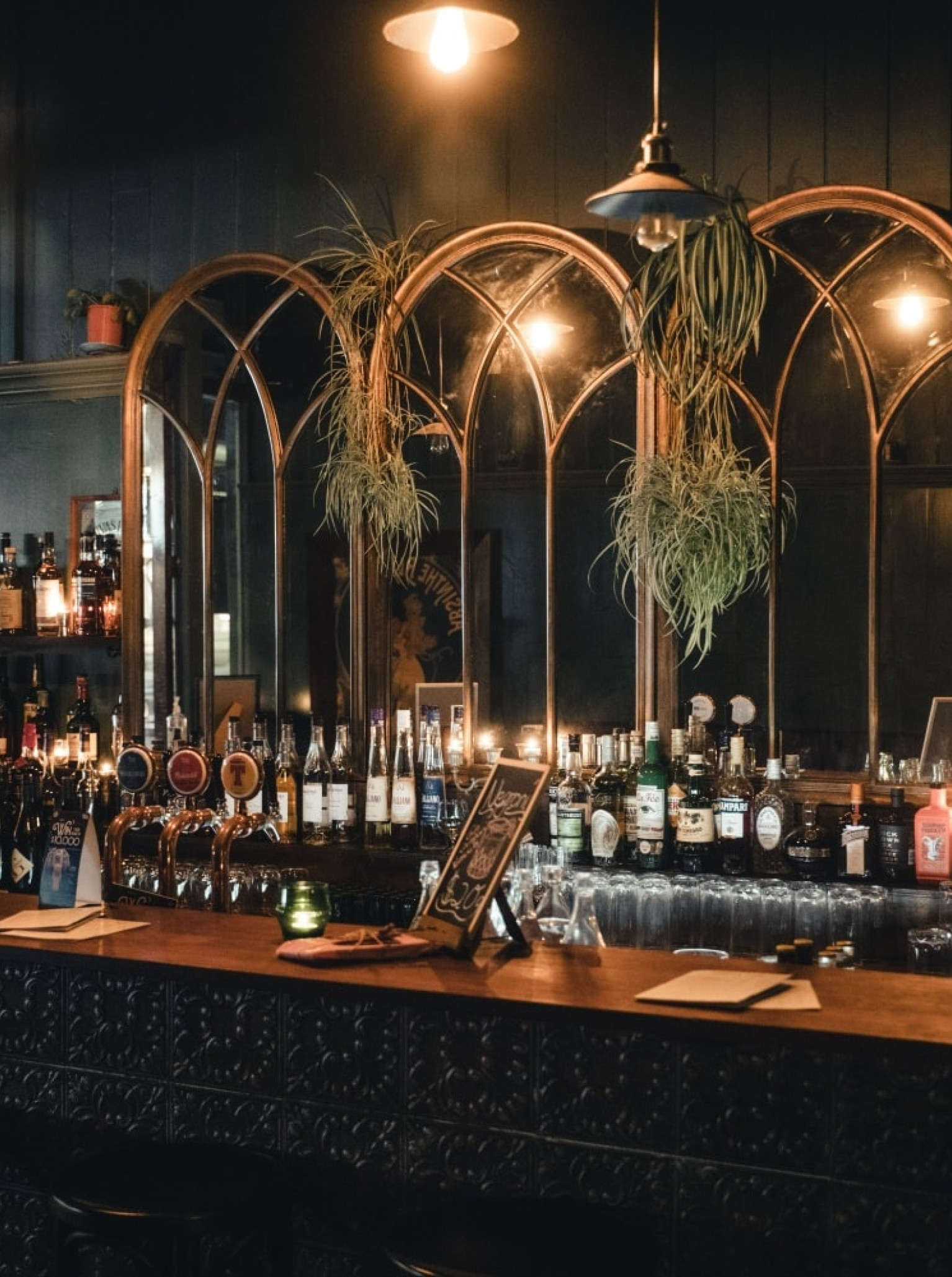 The Parisian-inspired vintage speakeasy bar at 39 Ponsonby, Auckland, features arched mirrors and warm, inviting lighting.