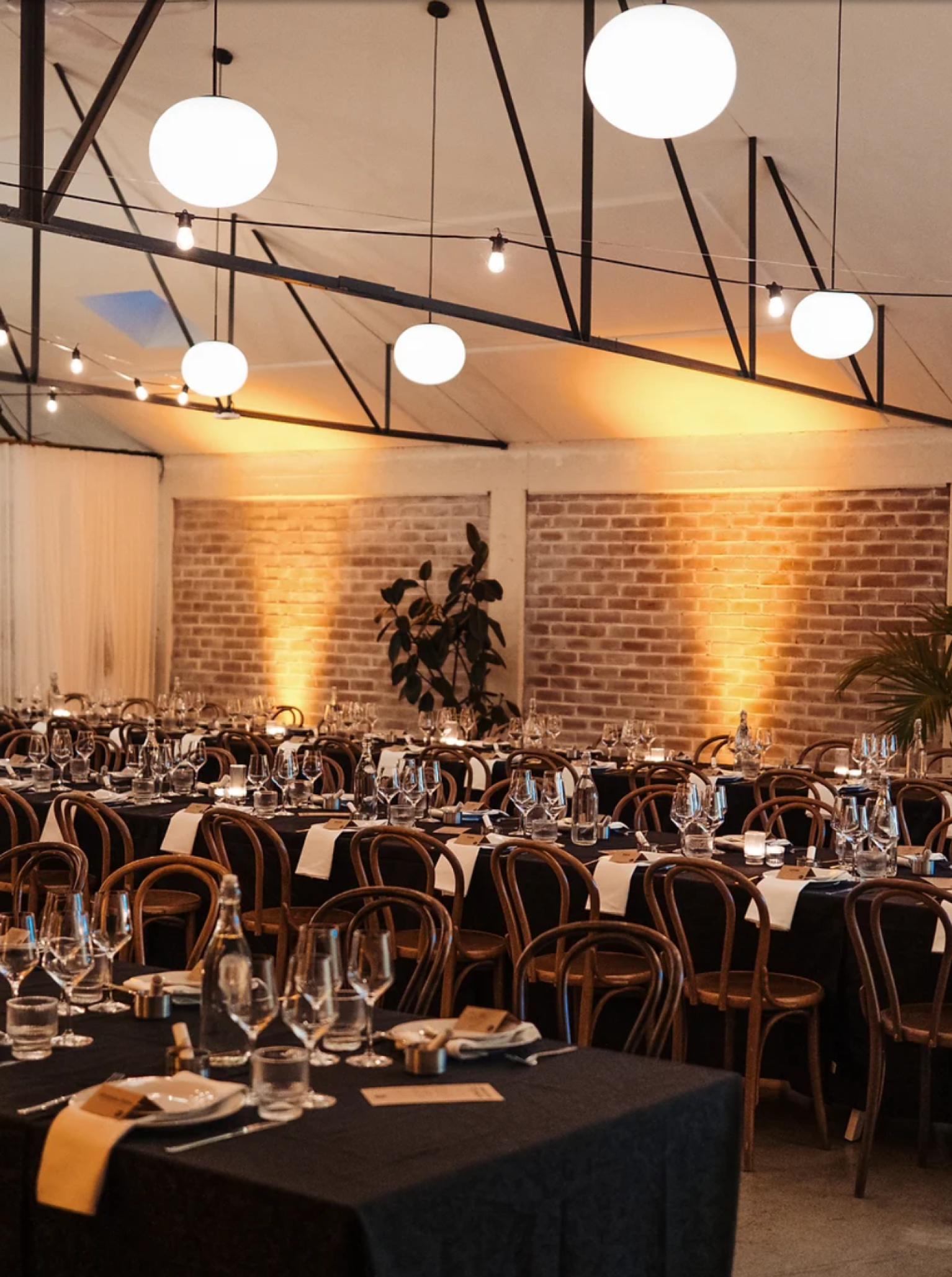 A reception setup in Whisky & Wood, Wellington's industrial-chic, New York loft-style event space, with long tables.