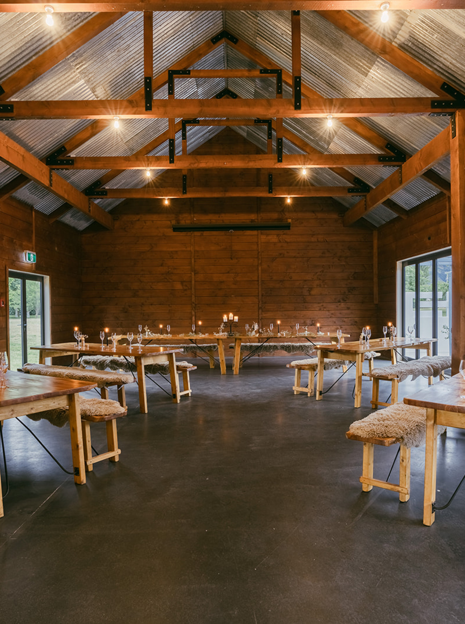 A rustic event space set for dining at The Venue Wānaka in Wanaka, featuring exposed timber and corrugated iron.
