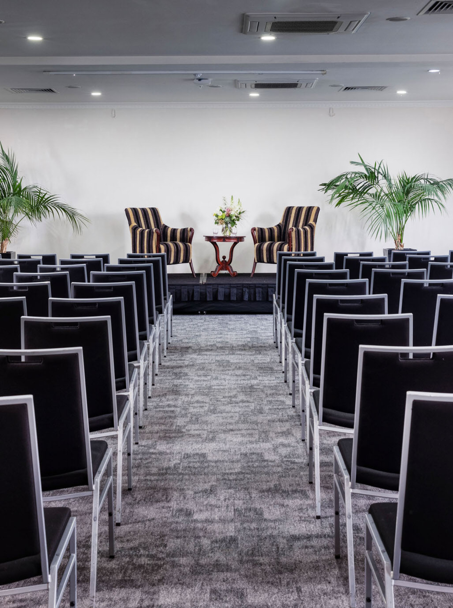 A flexible modern conference setup with rows of black chairs facing a stage at Arawa Park Hotel Rotorua.