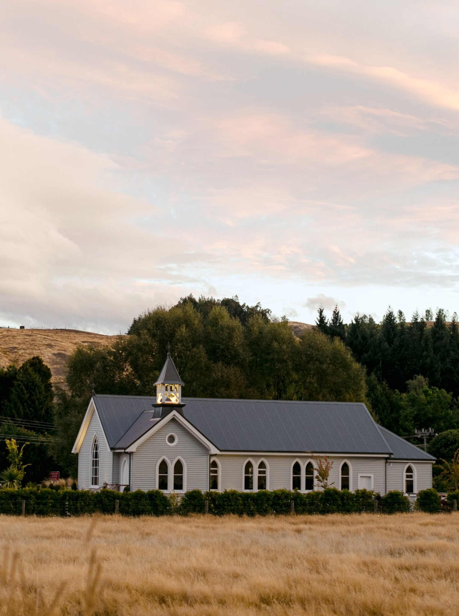 Waikākā Church in Queenstown is a beautifully restored century-old chapel, a picturesque venue nestled in a golden field.