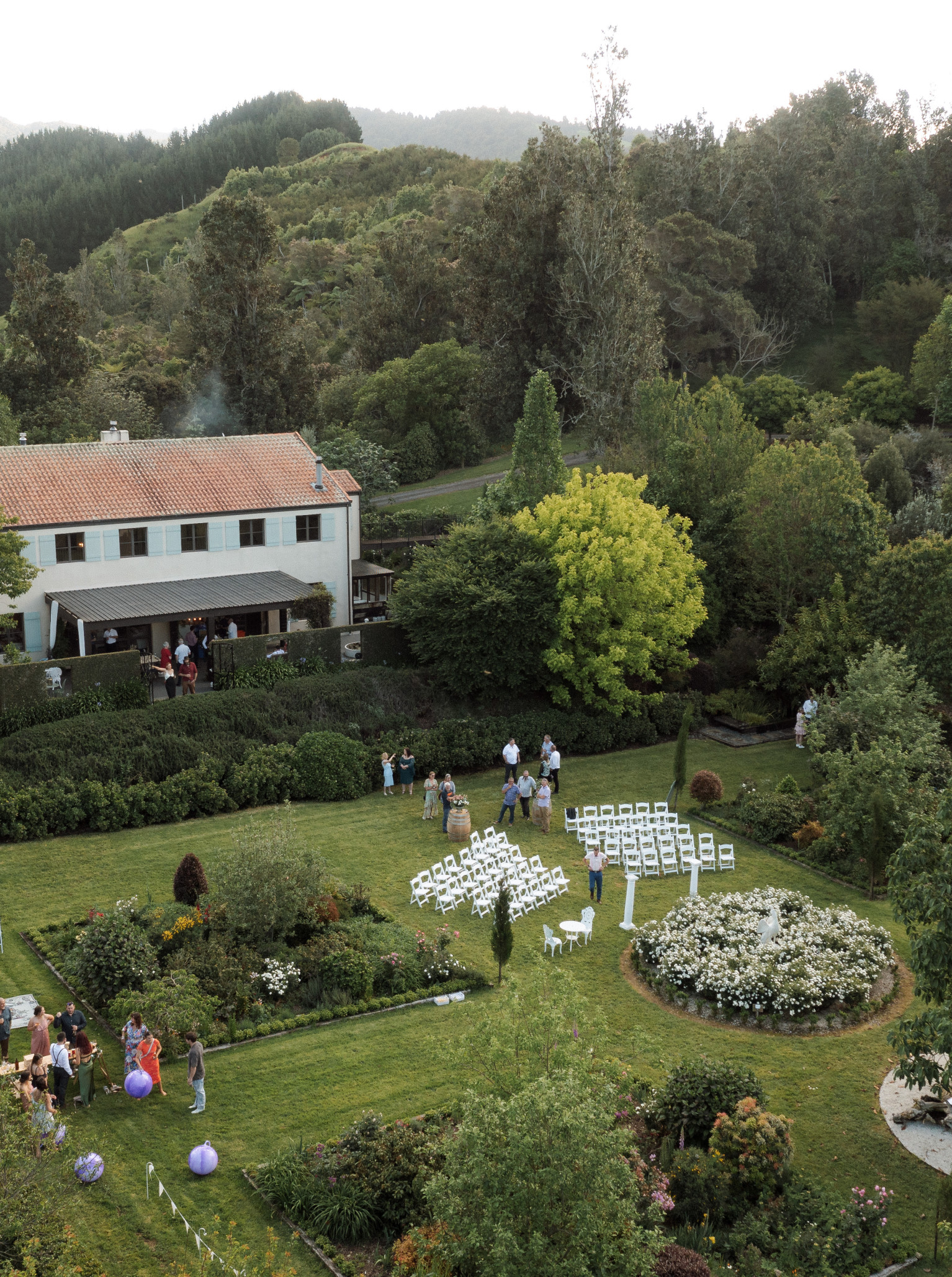 An outdoor wedding ceremony is set up on the manicured lawns of Villa Vie, a French-style homestead in Bay of Plenty.