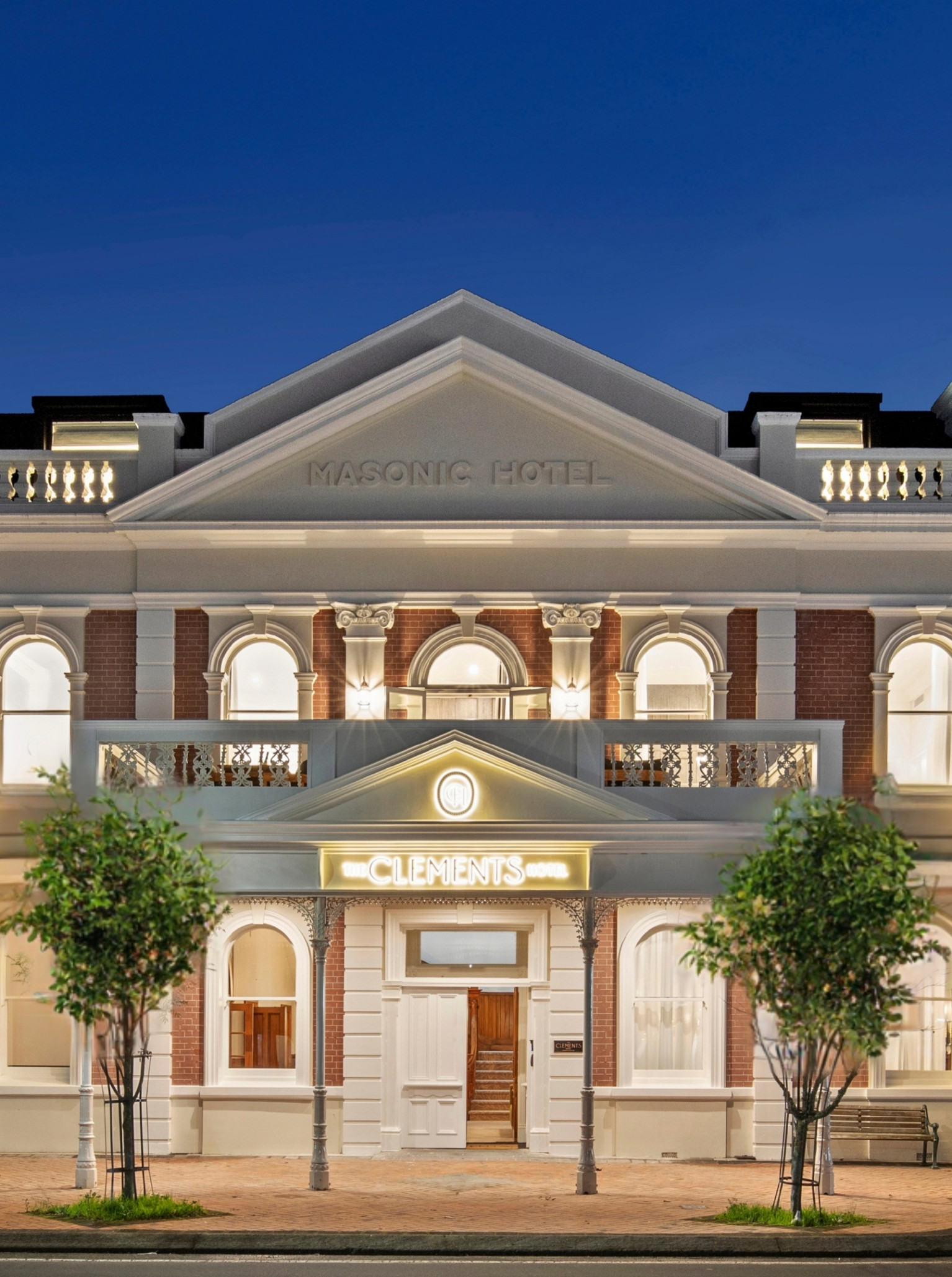 The historic Beaux Arts facade of The Clements Hotel in Cambridge, Waikato, glows at dusk.