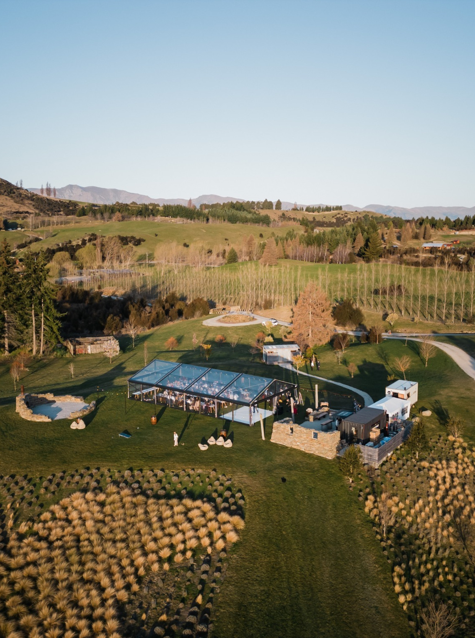 Guests dine in a clear-span tent at Dublin Bay Wanaka, a blank canvas venue nestled in the stunning New Zealand mountains.