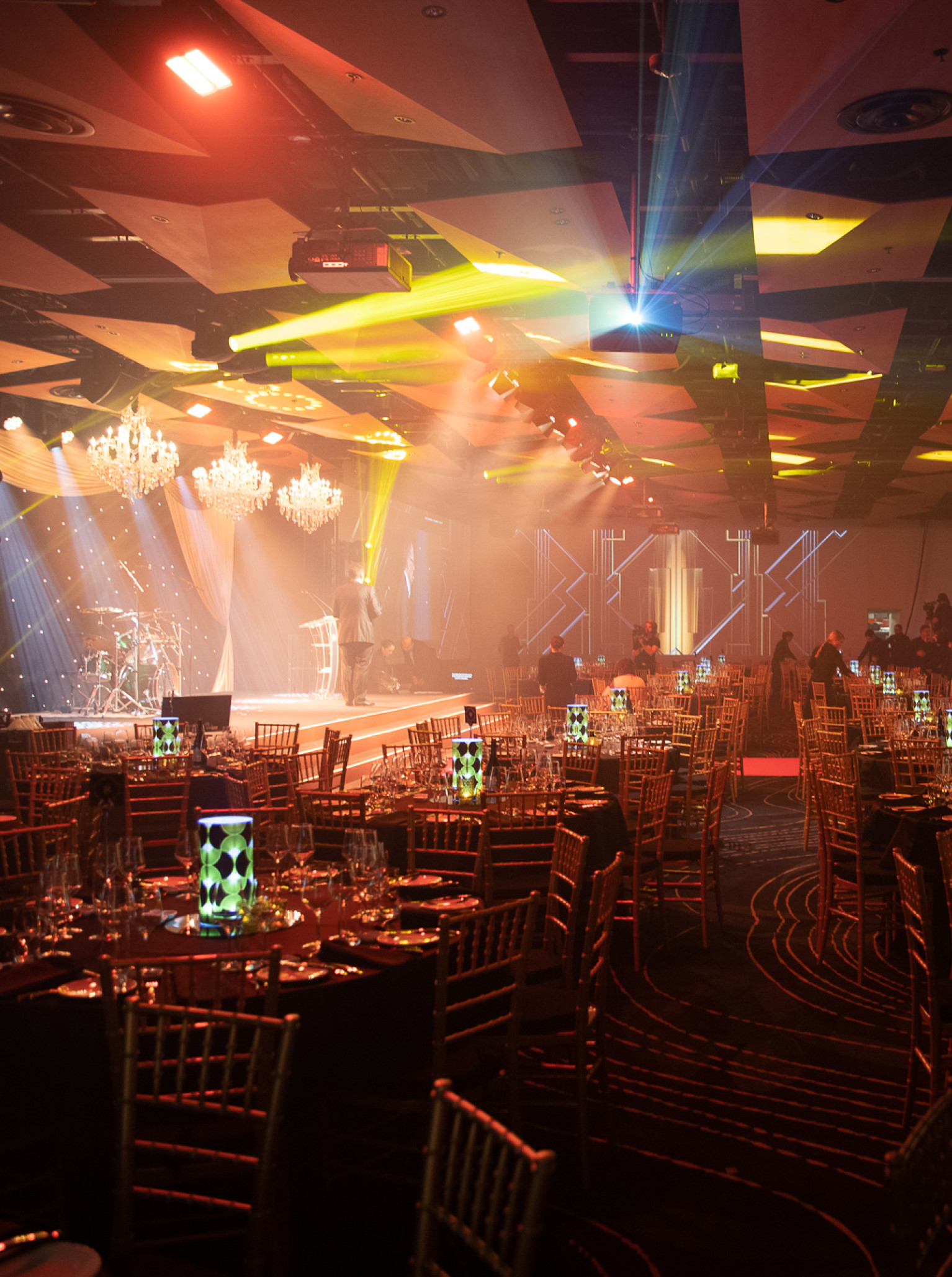 A contemporary gala dinner event setup with vibrant lighting and a stage at Auckland's Aotea Centre.