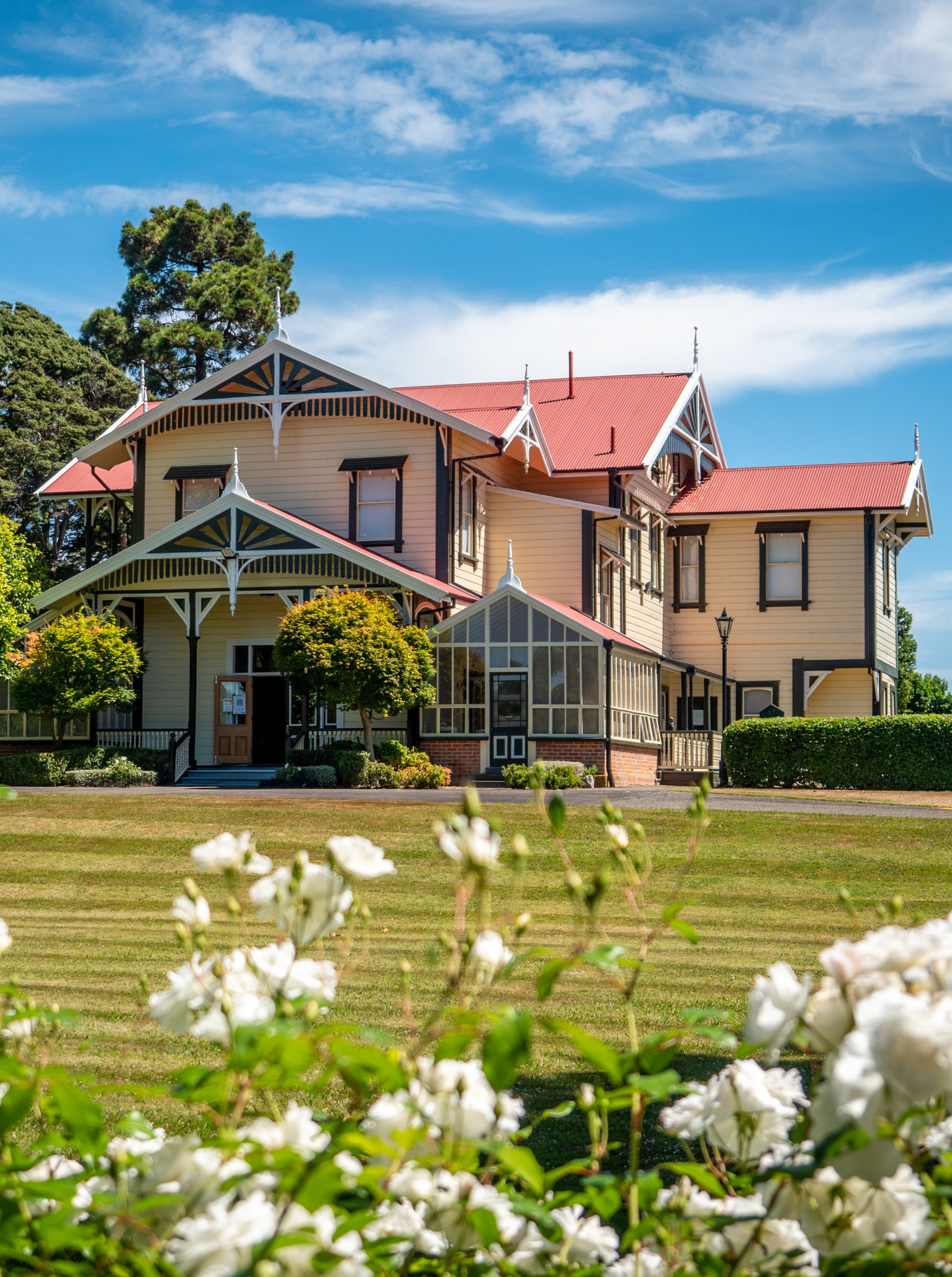 Caccia Birch House, a colonial homestead in Manawatū-Whanganui with Scandinavian design elements, stands elegantly amidst green lawns.