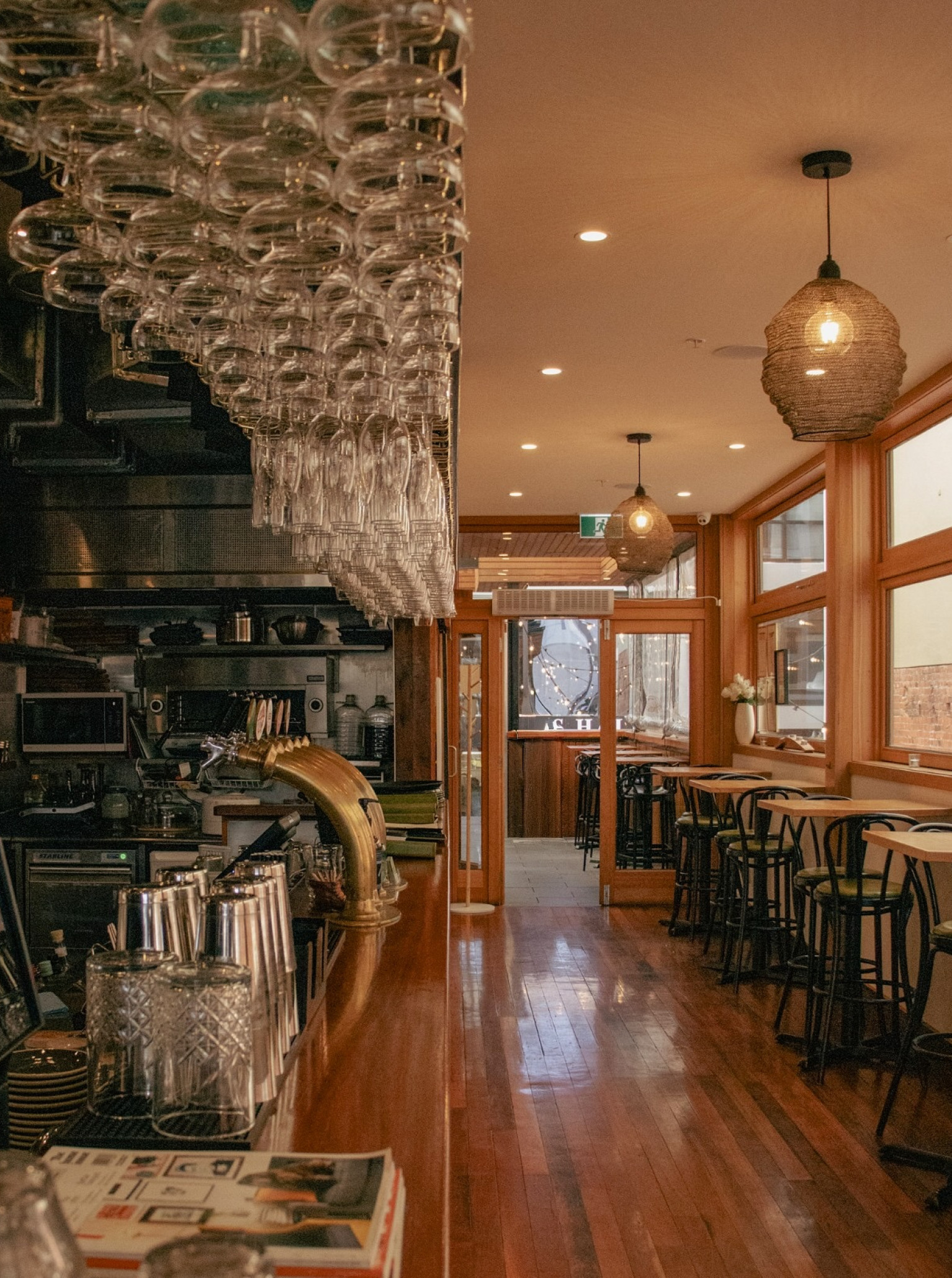 This image shows the industrial-chic bar and dining area at Amador, located within Wellington's historic Press Hall.