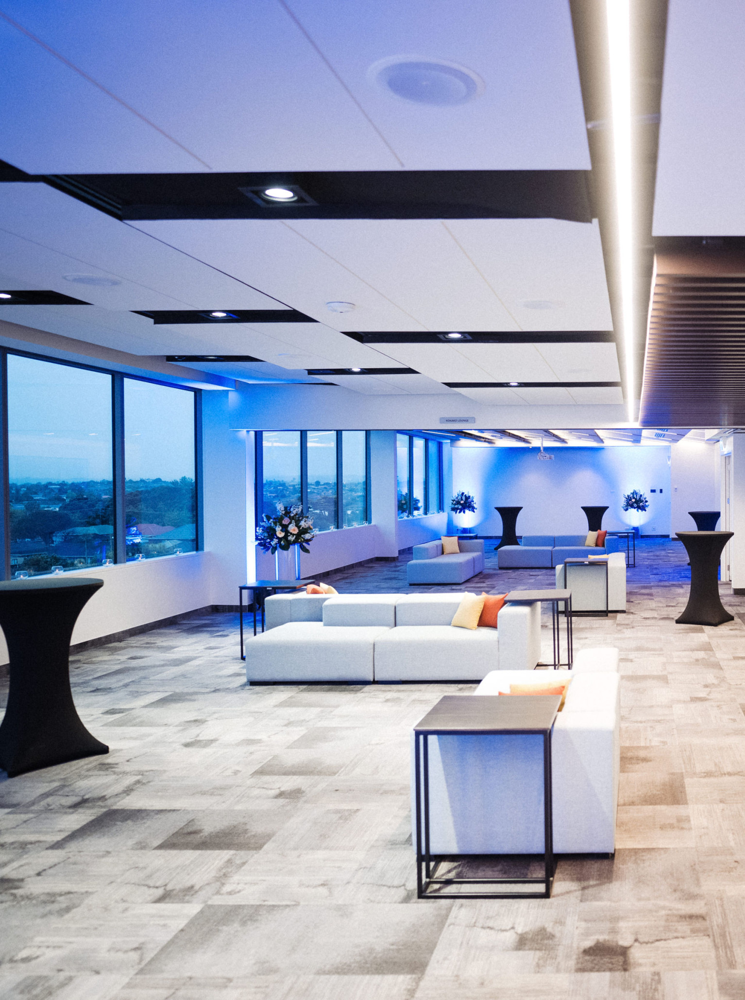 The modern and sophisticated event lounge and bar area at JetPark Auckland Hotel features sleek furnishings and panoramic windows.