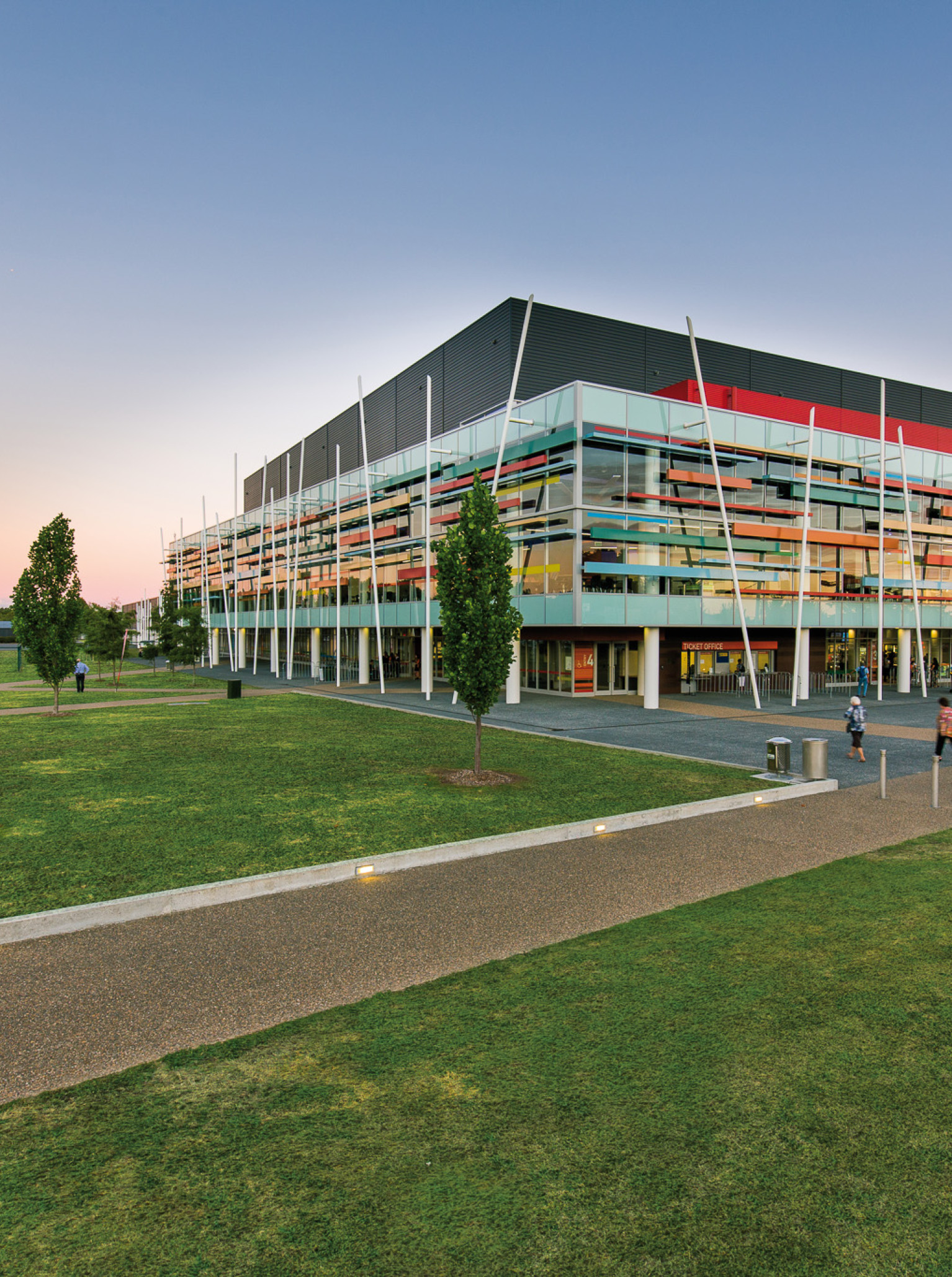 The modern Claudelands Events Centre in Hamilton features a vibrant, layered facade inspired by Maori heritage, surrounded by lush parkland.