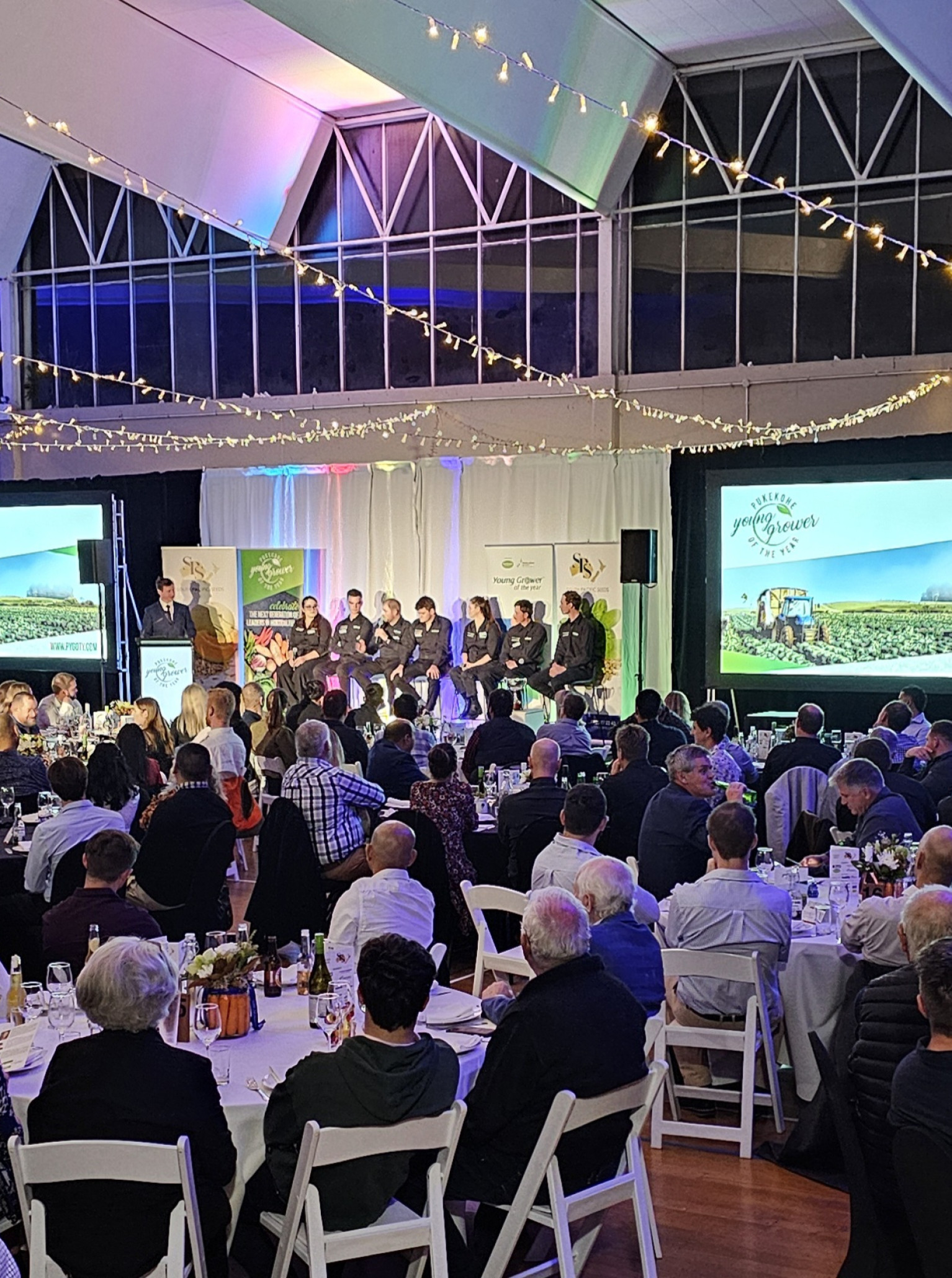 LaValla Auckland's modern, versatile event space hosts a formal dinner or conference, illuminated by elegant string lights.