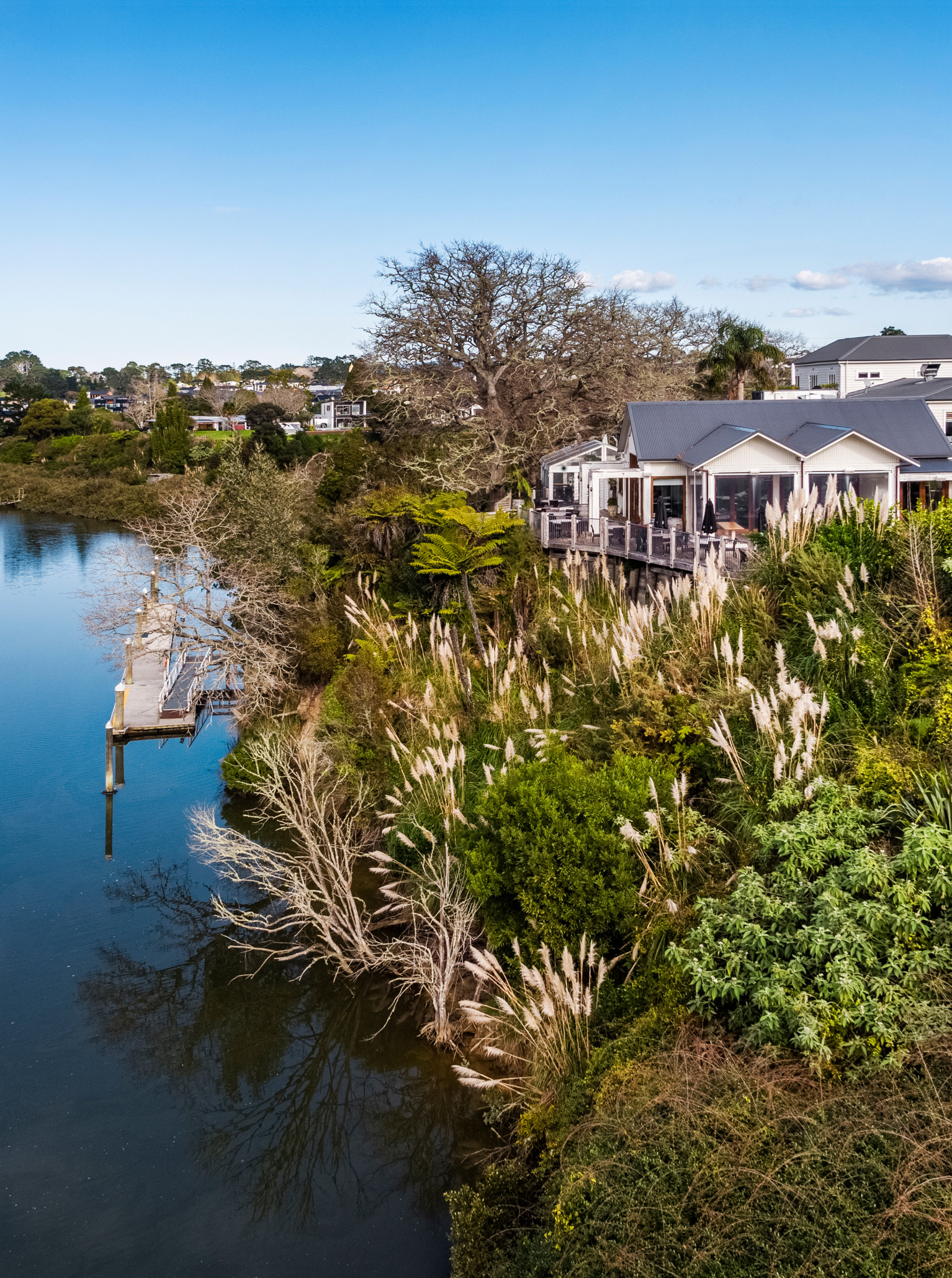 The Boat House in Auckland, an architecturally designed waterfront venue, features a spacious deck overlooking serene waters.