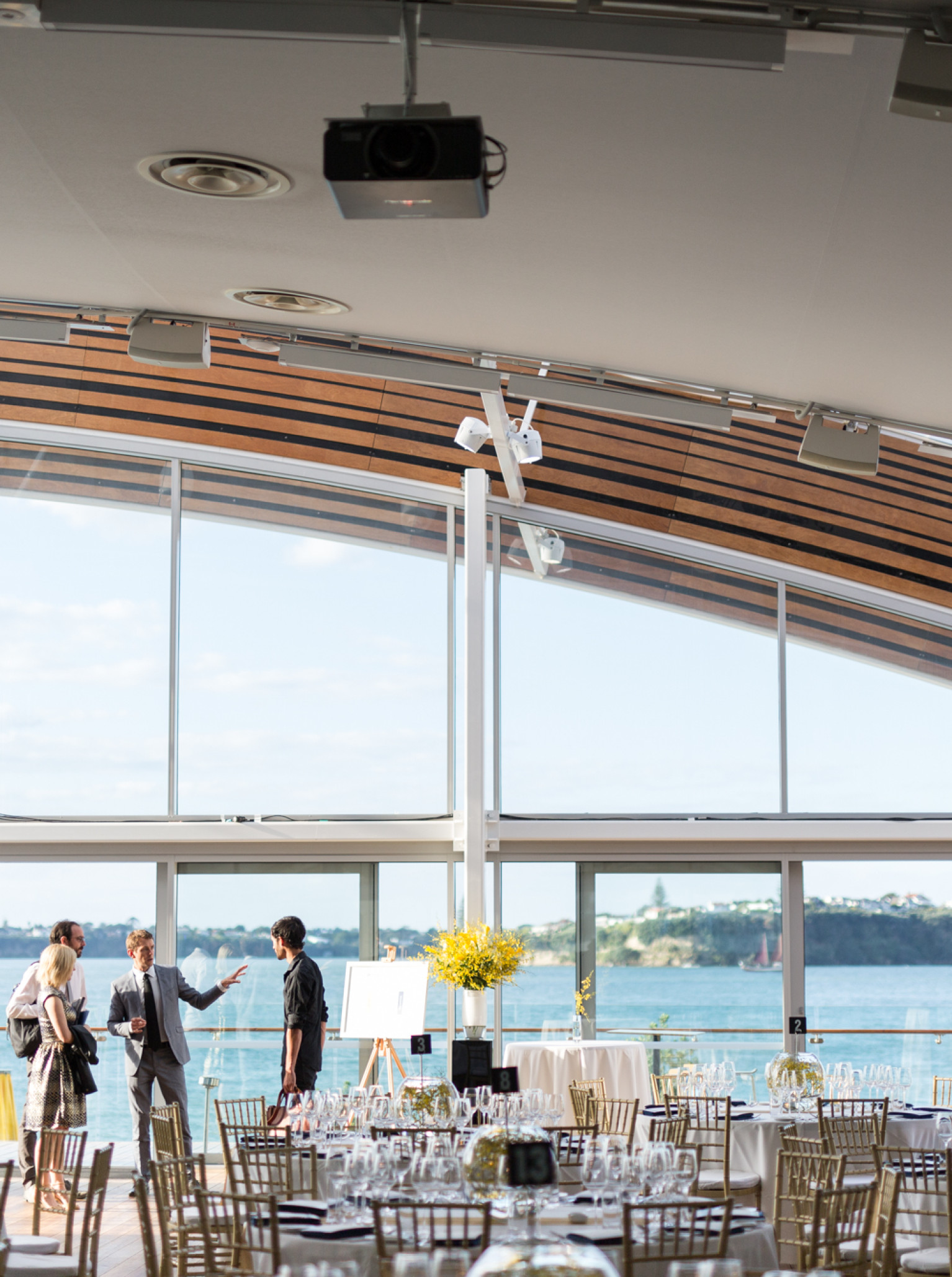 A modern, unique event space at The Cloud, Auckland, set for a banquet with panoramic waterfront views.