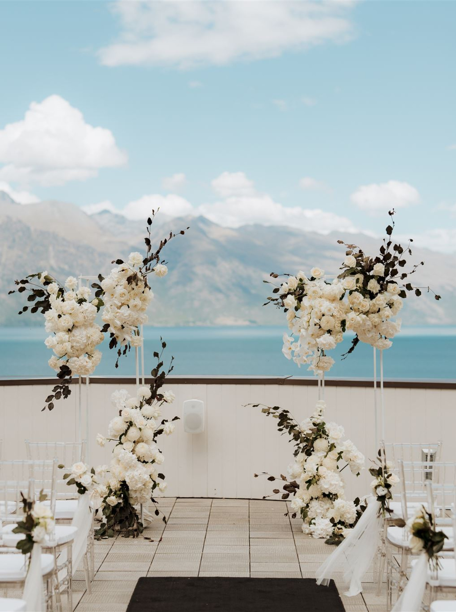 An outdoor wedding ceremony on the modern alpine lodge rooftop of Rendezvous Heritage Hotel Queenstown, with views of Lake Wakatipu.