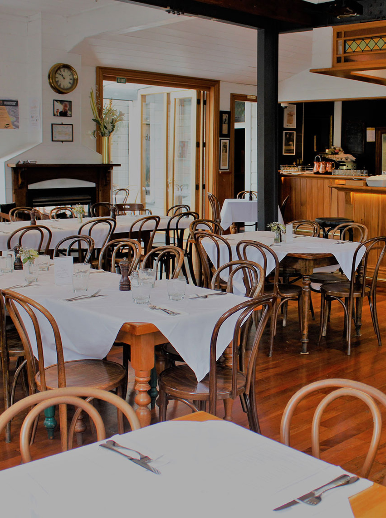 The historic timber Victorian dining room and bar at The Thistle Inn, Wellington, features set tables and a warm wooden interior.