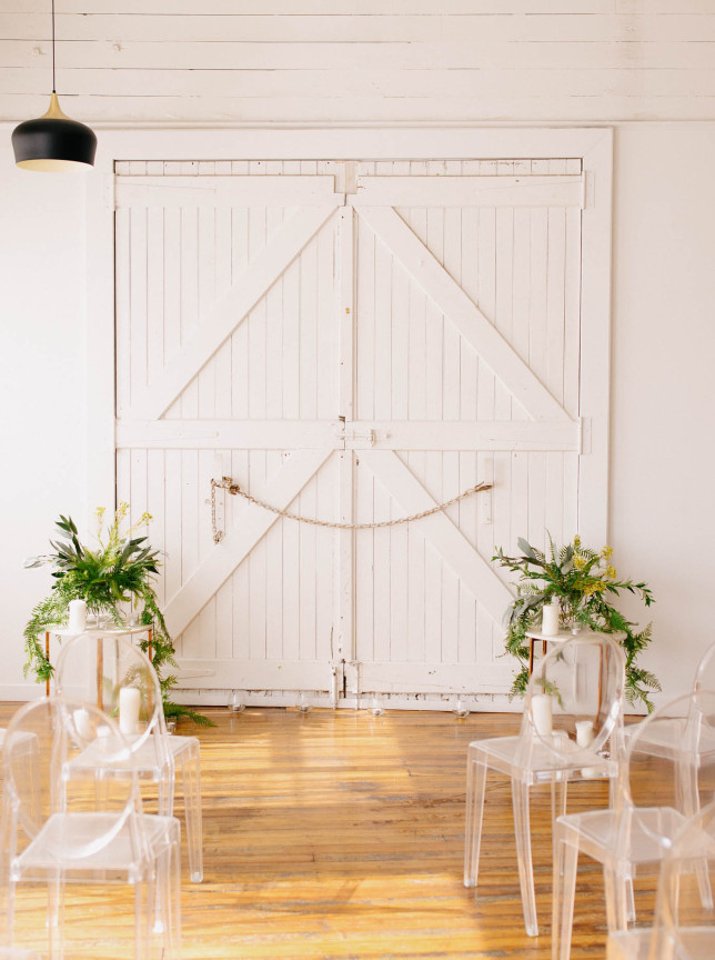 Ghost chairs await a ceremony in The Canapé Room, Wellington's chic inner-city loft space with rustic whitewashed doors and natural light.