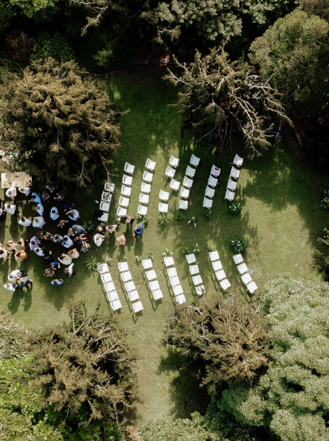 An outdoor wedding ceremony unfolds within the lush, manicured gardens of Anam Cara Gardens, Wellington.