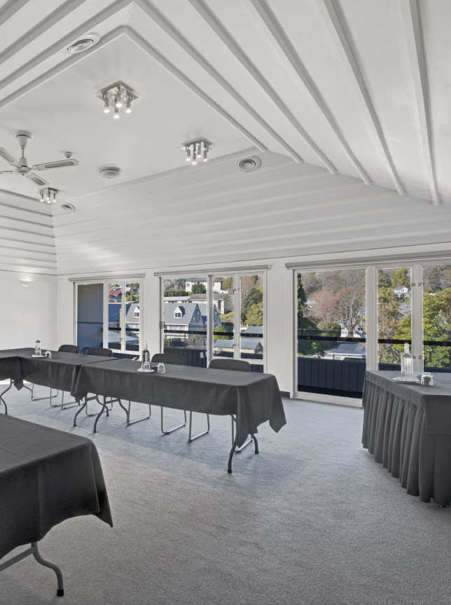 A modern U-shaped meeting room at The Hotel Nelson, Nelson-Tasman, featuring large windows and a distinctive ceiling.