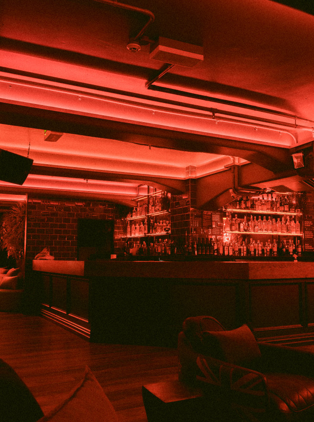 The Cellar Bar in Auckland features a dimly lit, contemporary underground bar with Irish-inspired interiors and red neon accents.