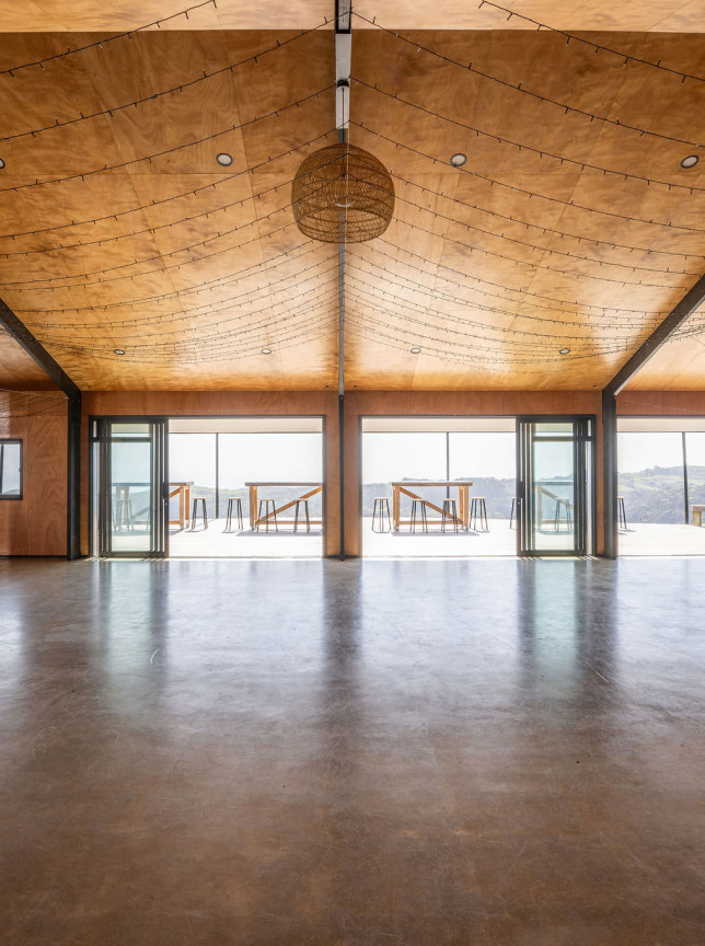The spacious event barn at Vanderosa Farms in Auckland features a natural wood interior, high ceilings, and panoramic deck views.
