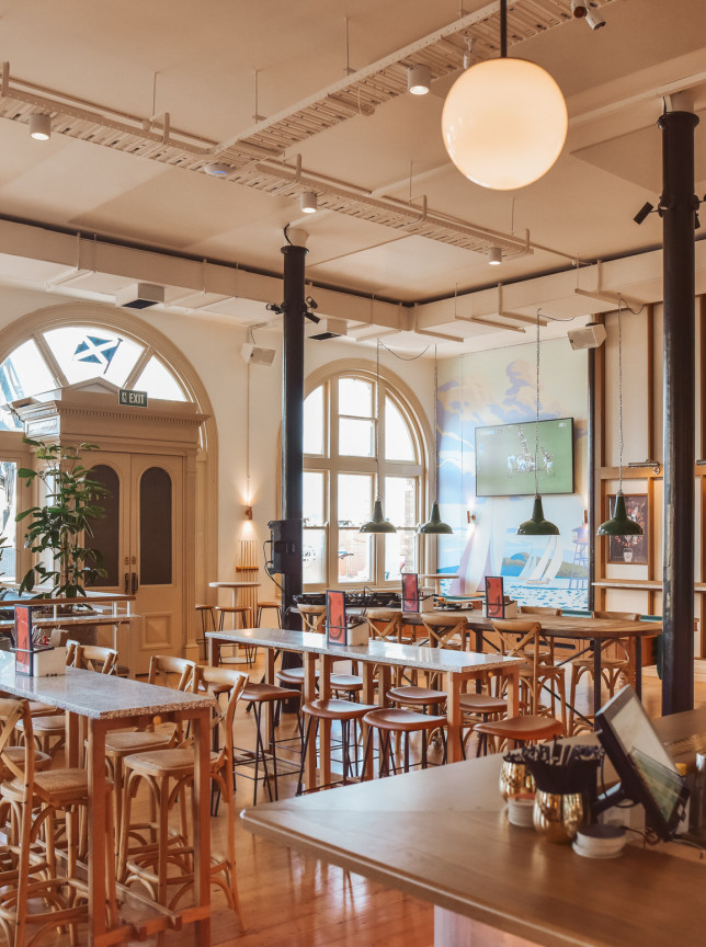 This modern gastropub dining area at The Brit in Auckland features elegant arched windows and warm timber accents.