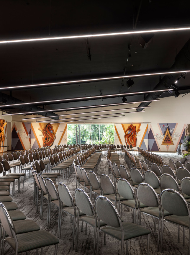 The Maori-themed conference room at Rydges Rotorua, set up theatre-style, showcases distinctive cultural artworks and a natural stage.
