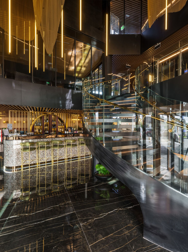SOHO Hotel Auckland's luxurious, art deco-inspired lobby bar and grand staircase feature gleaming gold and marble accents.