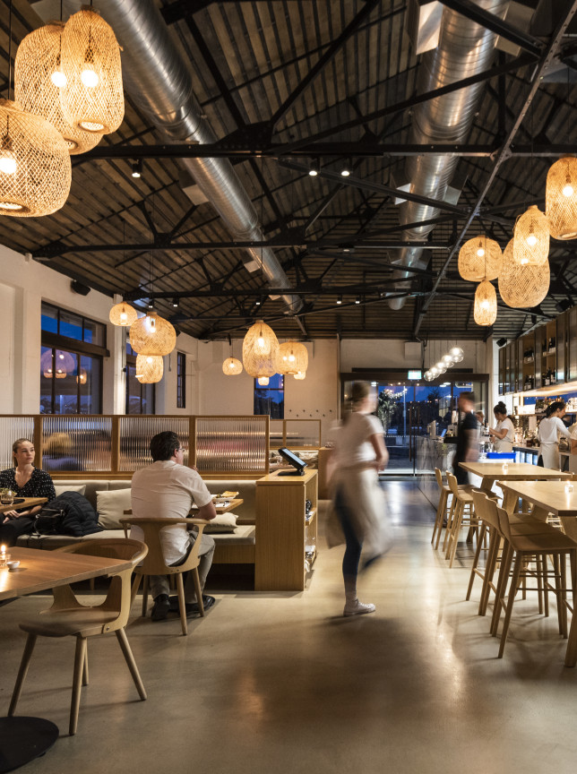 Auckland's Fabric Cafe Bistro offers a modern, high-studded industrial-chic dining space with warm, woven lighting.
