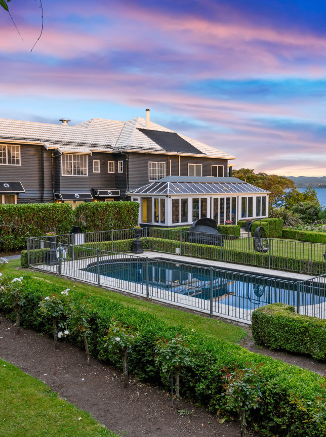 An outdoor pool and Victorian-styled gardens at the elegant Black Swan Lakeside Boutique Hotel in Rotorua, overlooking the lake.