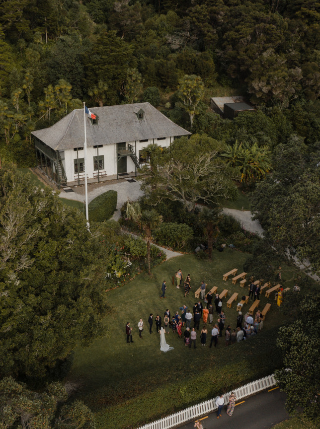 An outdoor wedding ceremony is held on the lawn of the historic French colonial Pompallier Mission and Printery in Northland.