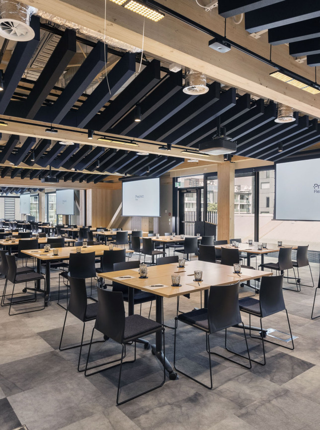 A modern, timber-detailed conference and event space at Pipiri Lane by Precinct Flex in Auckland, featuring multiple screens.