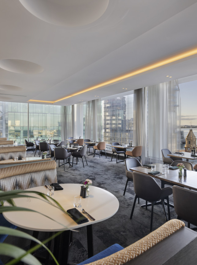 A modern and elegant dining room at Mövenpick Hotel Auckland offers panoramic views of Auckland's harbor.