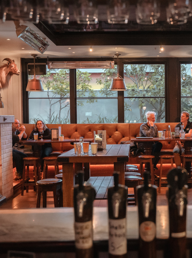 Carlton Bar, Christchurch, features a modern steakhouse interior with tufted booth seating and warm, inviting lighting for guests.