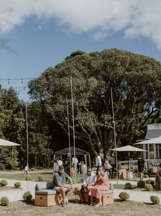 Guests socialize at an outdoor event in the lush gardens of Tatum, a historic homestead venue in Manawatū-Whanganui.
