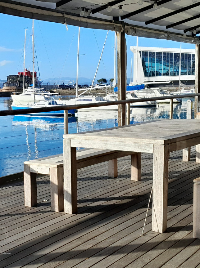 Maritime-inspired outdoor deck seating at Royal Port Nicholson Yacht Club, Wellington, with expansive marina views.