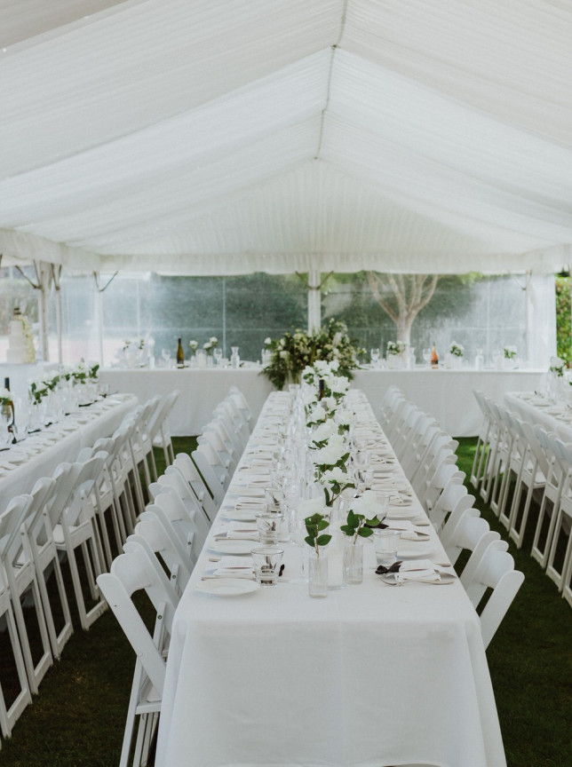 An elegant wedding reception is set in a white tent on the lawns of the charming Parehua Resort, Martinborough.