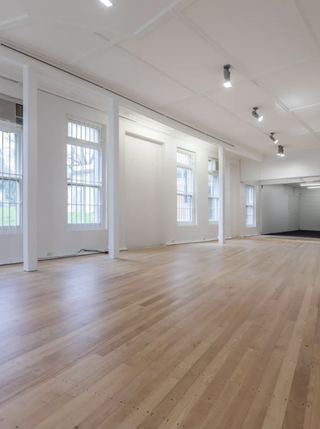 An open, versatile dancehall event space with light wood floors and white walls at Small Rave in Auckland.