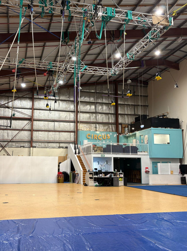 Wellington's Circus Hub offers a vast industrial-style aerial training space with high ceilings, rigging, and a vibrant turquoise office.