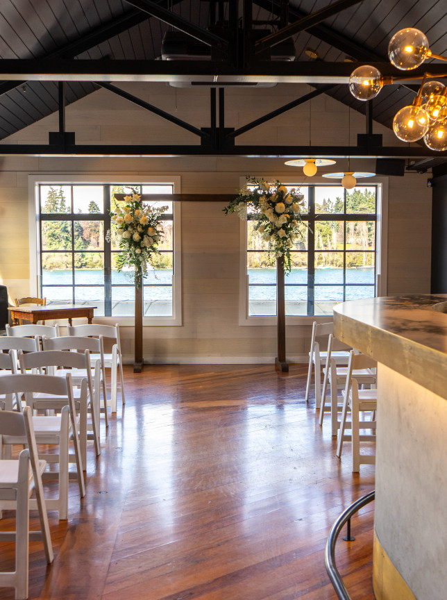 A modern nautical-themed ceremony space at Boardwalk Queenstown, featuring white chairs and stunning lake views.
