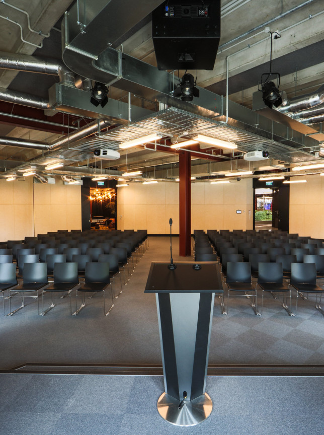 B:HIVE Auckland's architect-designed auditorium setup for a presentation, with exposed industrial ceiling elements.