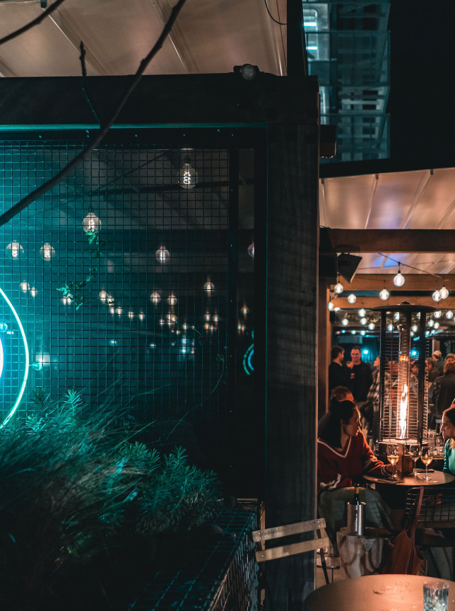 Fantail & Turtle, Auckland's trendy, architecturally designed outdoor bar, shines with ambient lights and a neon sign for evening gatherings.
