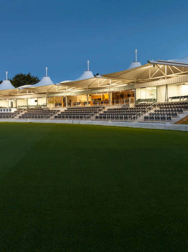 The Hadlee Pavilion's distinctive tensile roof structure illuminates the spectator stands and cricket field at Hagley Oval, Christchurch.