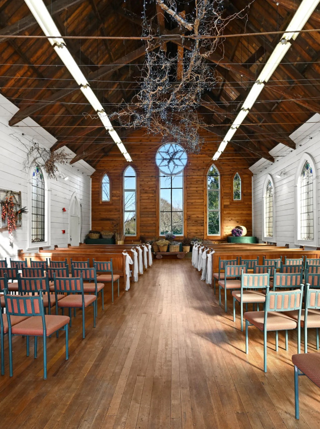 A historical chapel ceremony space, featuring original leadlight windows and a wooden ceiling, at Gails of Tamahere in Hamilton.