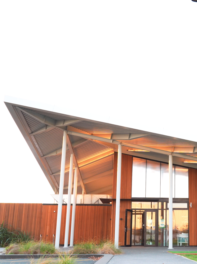 The modern, angular pavilion of PERCY in Auckland features expansive glass and warm wooden panels.