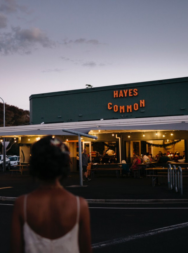 A couple approaches the vibrant outdoor dining area of Hayes Common, a relaxed mid-century-inspired eatery in Hamilton.
